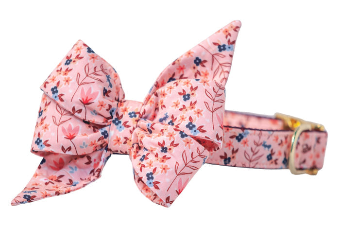 Stylish pink dog collar adorned with a detachable oversized belle bow in the same floral and bee print, featuring sturdy stitching along the edges and polished hardware for fastening.