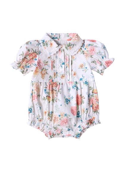 The Ivy City Co Baby Sophia Romper in Countryside Peony Blossom features a floral cotton design with puffed sleeves, Peter Pan collar, pink, blue, and yellow print on white, plus buttons and elastic leg openings for easy changing.