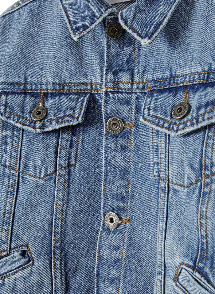 Close-up of a boys denim jacket in navy with button fastening and flap pockets.