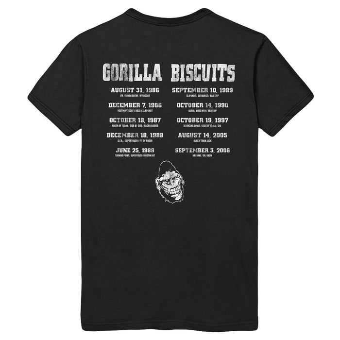 Gorilla Biscuits black Gildan heavy cotton t-shirt featuring the band name in bold white letters, a back print with tour dates, cities, and a white gorilla illustration near the lower back center.