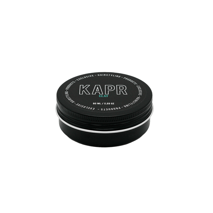 KAPR Clay – kleine zwarte pot met wit logo op grijze achtergrond, matte hairstyling clay 60ml.