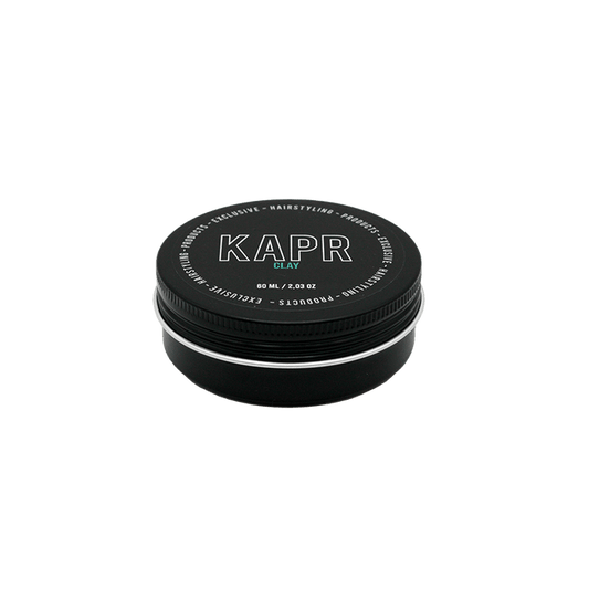 KAPR Clay – kleine zwarte pot met wit logo op grijze achtergrond, matte hairstyling clay 60ml.