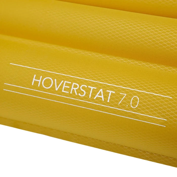 מזרון טיולים מתנפח Hoverstat 7.0 מקופל בתוך שק האריזה הקומפקטי שלו לצד בקבוק מים
