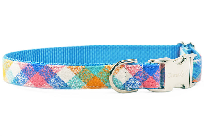 A colorful flannel, pastel dog collar featuring cheerful checks in pink, orange, and blue, with a bright lining and polished hardware.