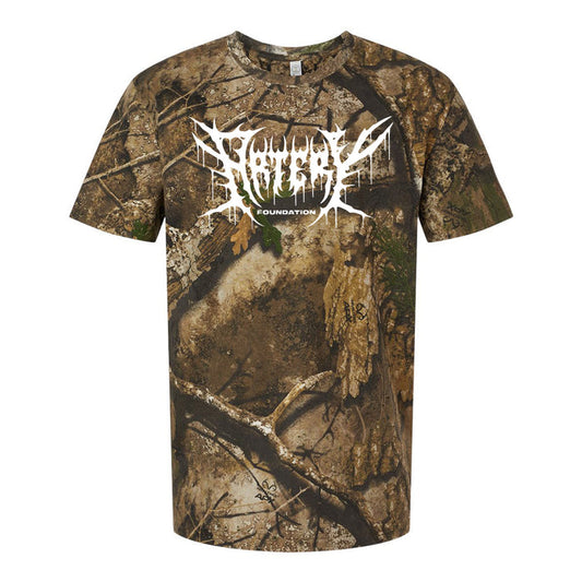 A short-sleeve t-shirt with a brown and green camouflage pattern, featuring rugged REALTREE styling. “ARTERY FOUNDATION” is printed in large, white, jagged letters across the shoulders on the back.