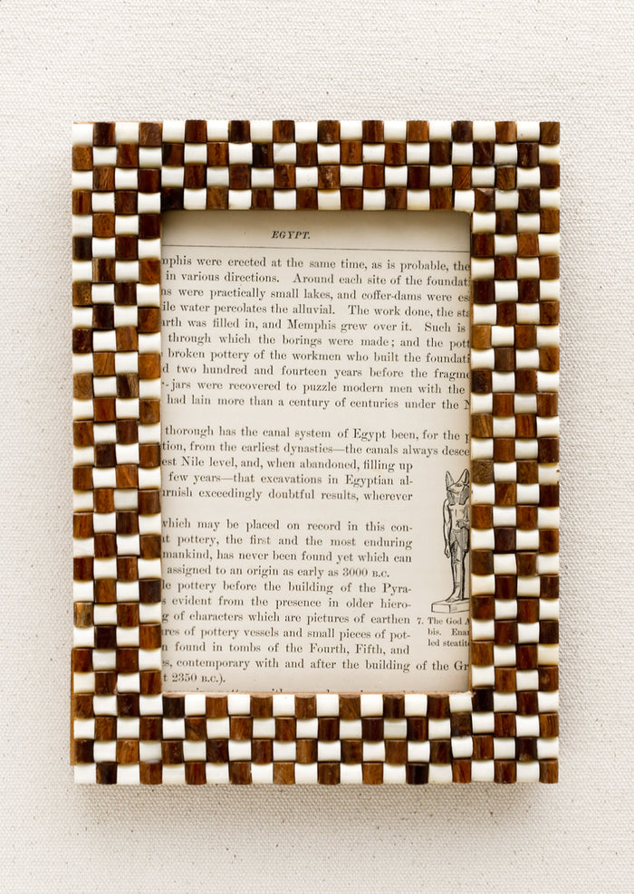 A picture frame with textural raised brown and white checker weave pattern.