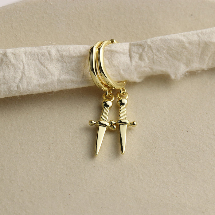 Mini daggers hoop earrings in gold vermeil over sterling silver with a snap close. Earrings are styled over a piece of fiber.