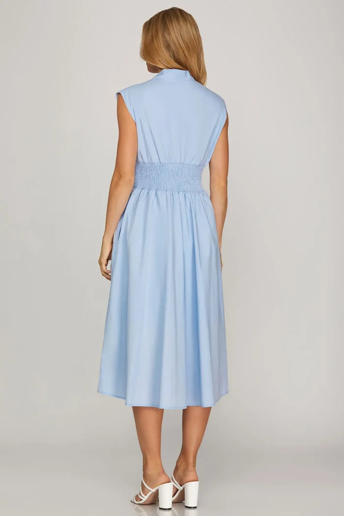 Woman wearing a light blue dress on a plain background