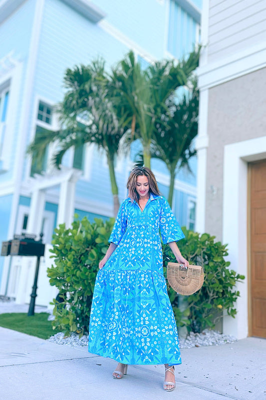Model in a blue/ aqua patterned tiered maxi dress, with touches of green and white and other shades of blue