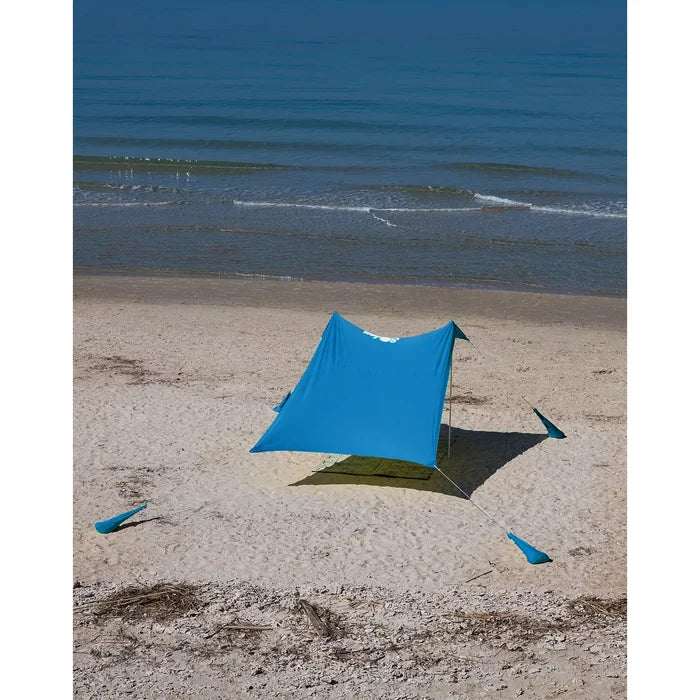 ציליית ים כחולה Soley 2.8X2.8 של Outdoor Revolution מתוחה בחוף עם מוטות אלומיניום ושקי חול