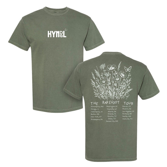 Front and back of a green Kyndal Comfort Colors T-Shirt. "KYNOL" in white on the chest; back shows white wildflowers, a butterfly, and cities under "The Barefoot Tour." Made from soft, garment-dyed ring-spun cotton.