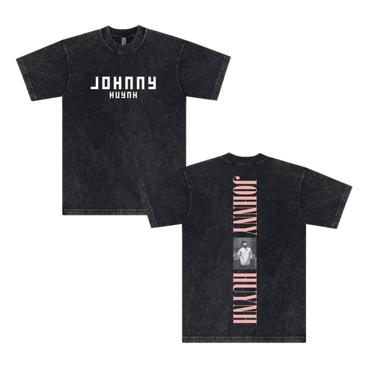Front and back views of a black mineral wash unisex T-shirt by Johnny Huynh, with bold white JOHNNY HUYNH text on the front and a vertical pink JOHNNY HUYNH plus grayscale photo on the garment dye cotton back.
